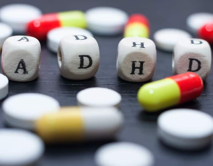 ADHD Treatment with medication. Picture shows cubes with the letters "ADHD" and tablets underneath relating