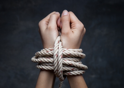 Stockholm Syndrome provides an extreme illustration of identification with the aggressor. The picture shows hands of a victim bound with a rope 