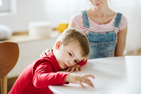 Life Course of ADHD. Picture shows a desintersted child with adhd and his mother in the background